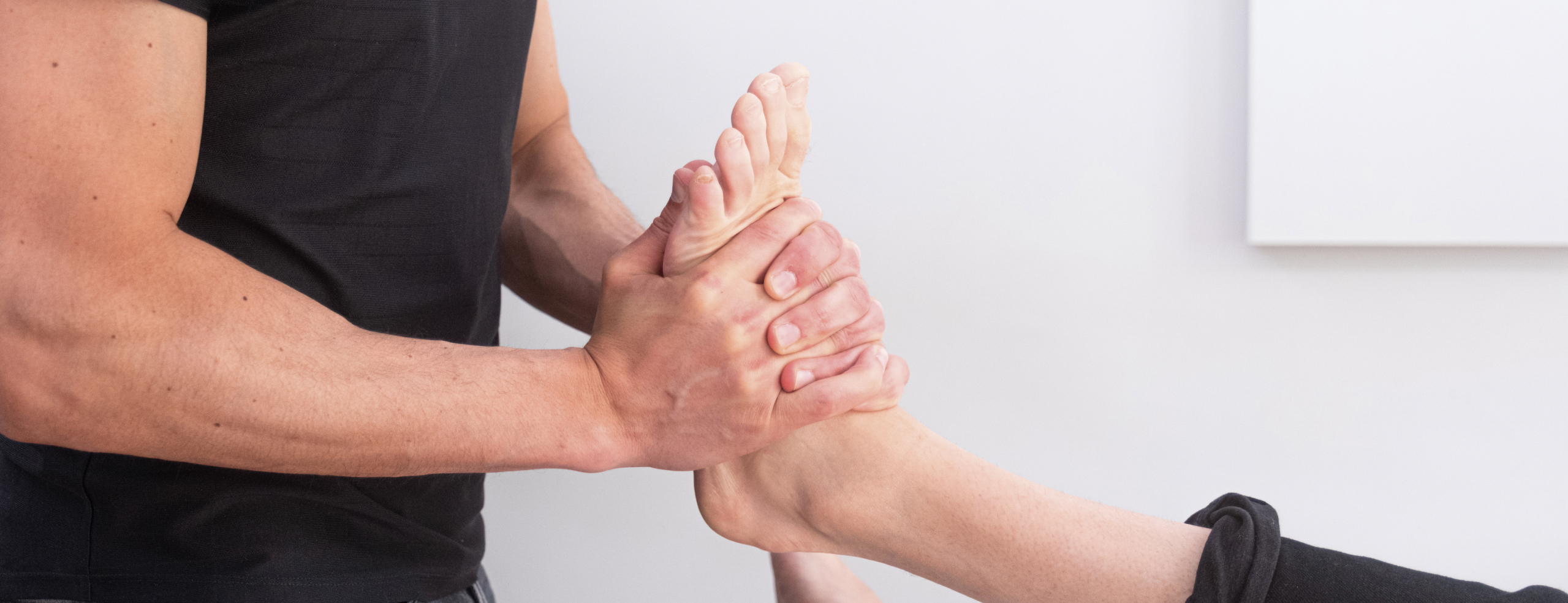 Kinésithérapeute appliquant un massage sur le pied d’un patient allongé - Nevrome de morton | Koss Sport Paris